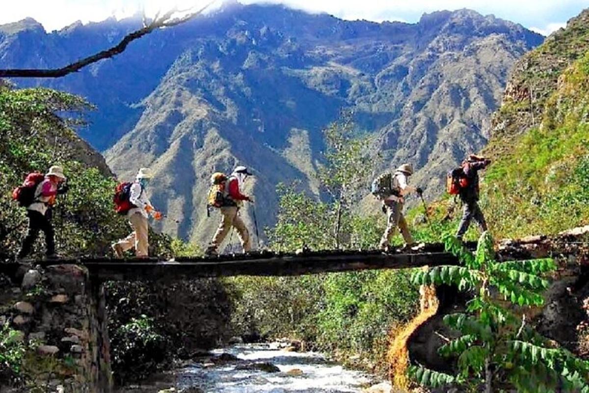 sekumpulan orang berjalan melintasi jambatan di atas sungai