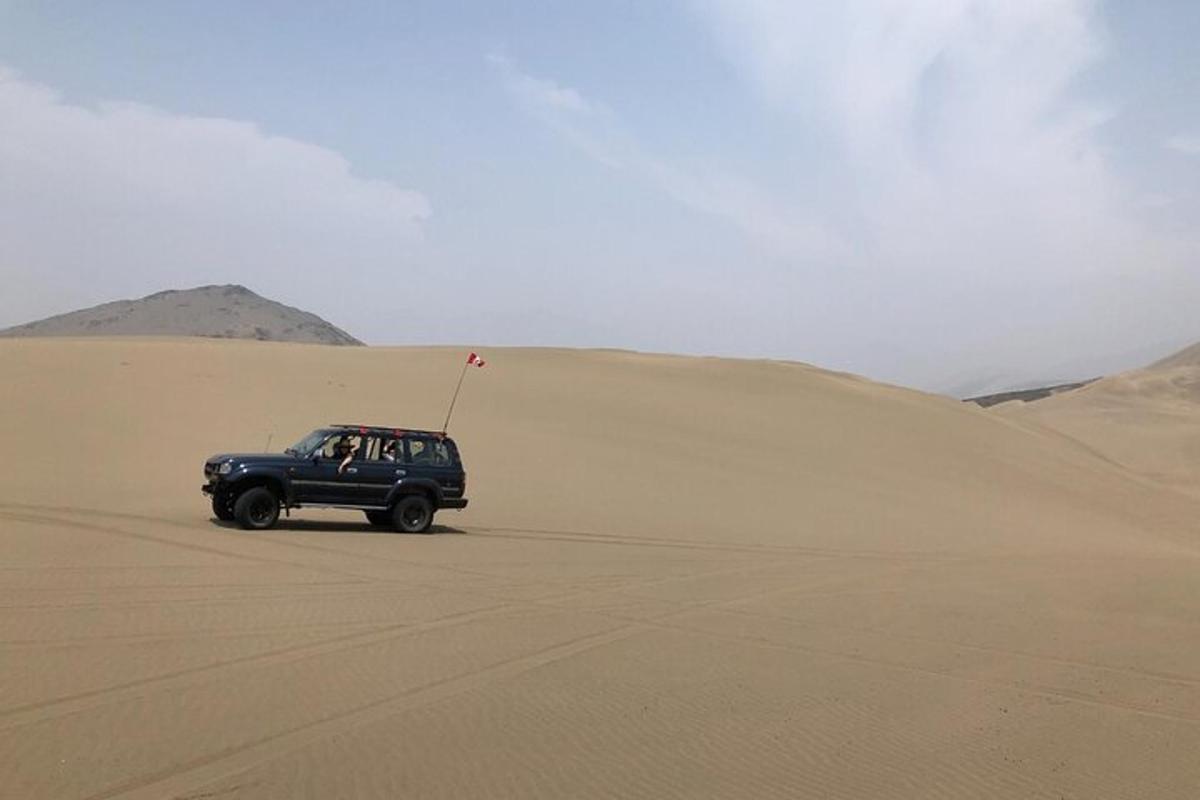 una jeep che percorre una duna di sabbia nel deserto