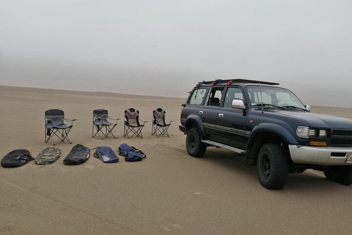 un camion parcheggiato nel deserto con zaini e sedie