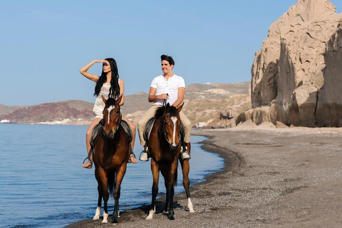 moški in ženska jahata konje na plaži