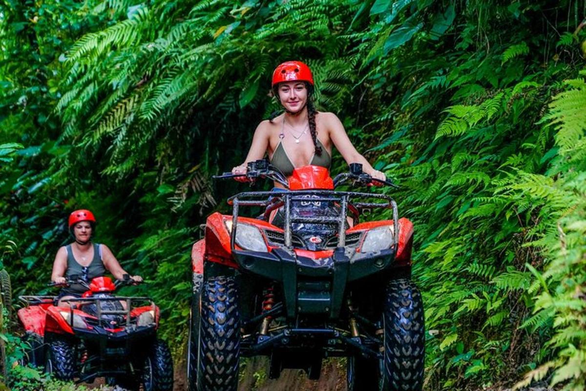 Două persoane care călătoresc pe ATV-uri în pădure