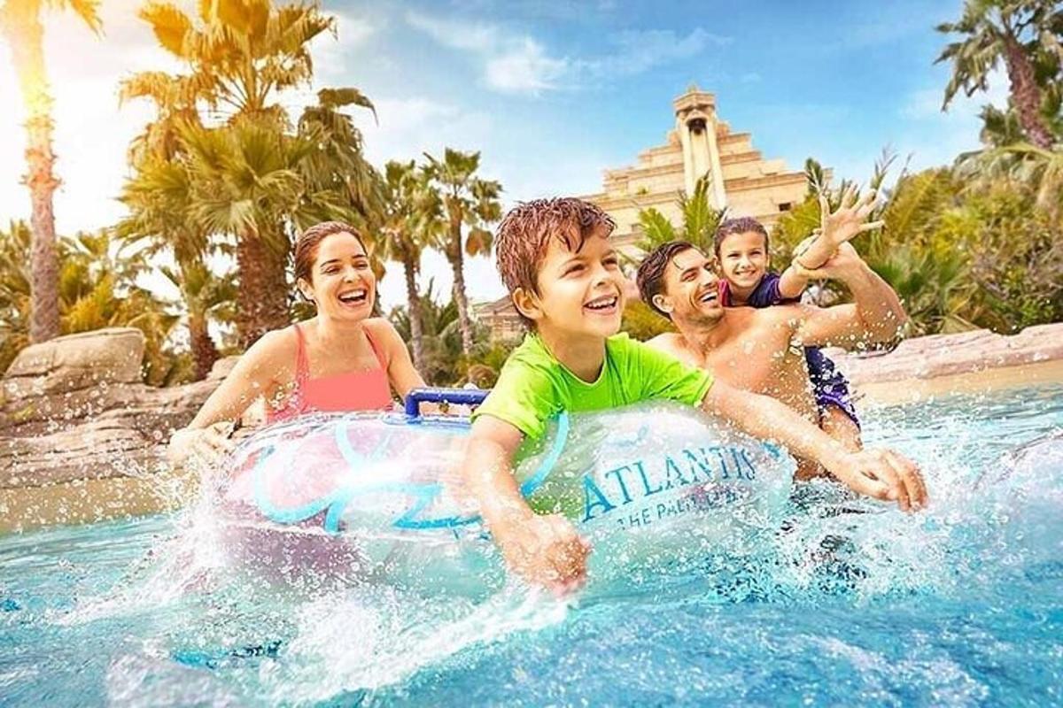 Un grupo de niños jugando en una piscina en un complejo turístico.