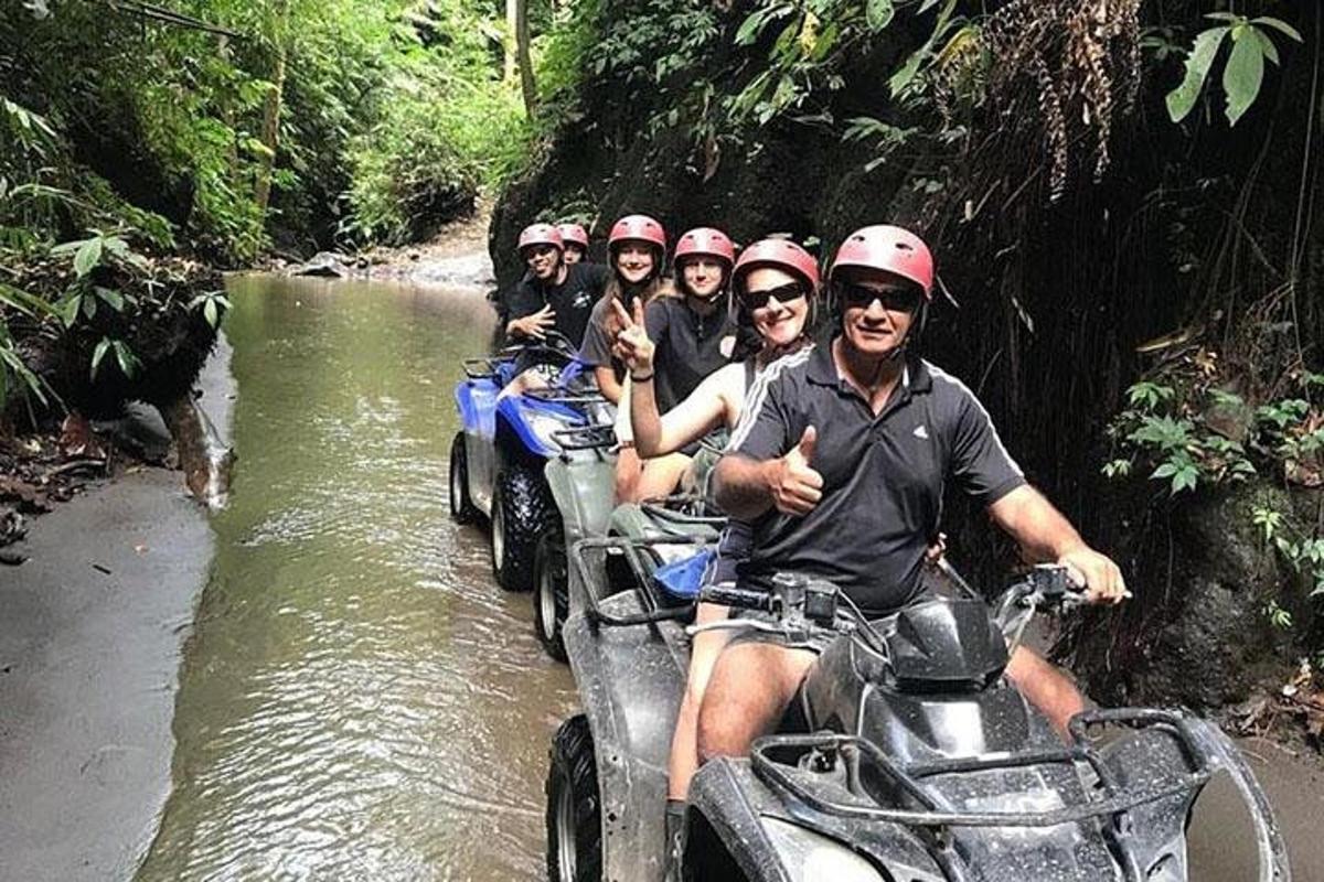 um grupo de pessoas andando de quadriciclo em um rio