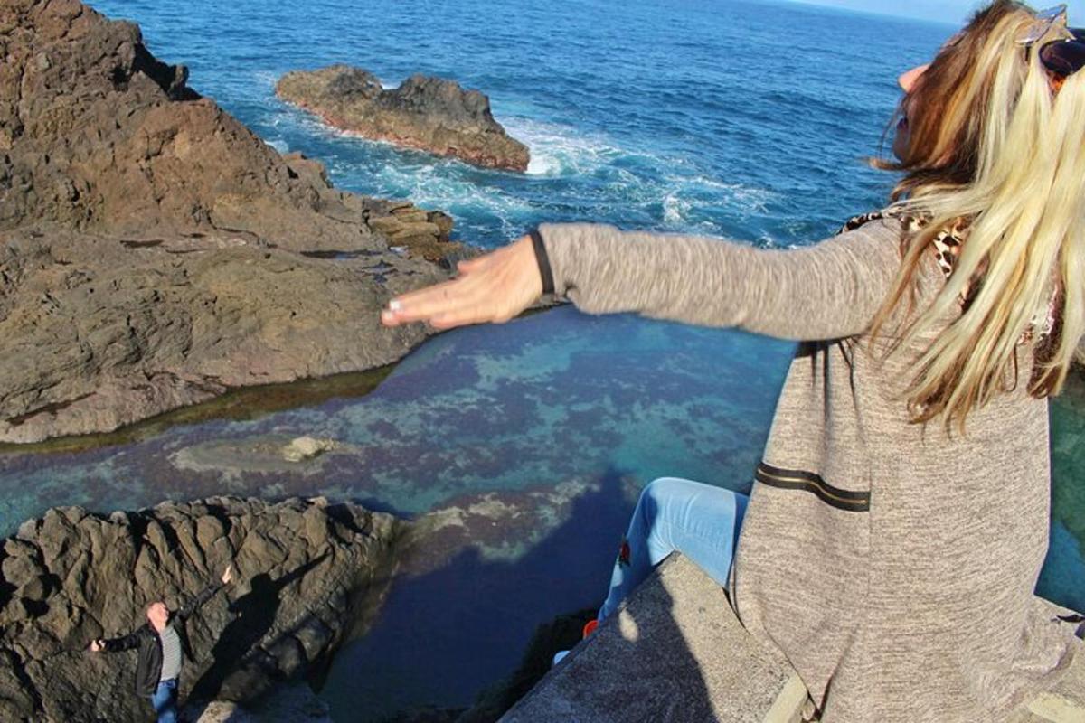 žena stojící na útesu a dívající se na oceán