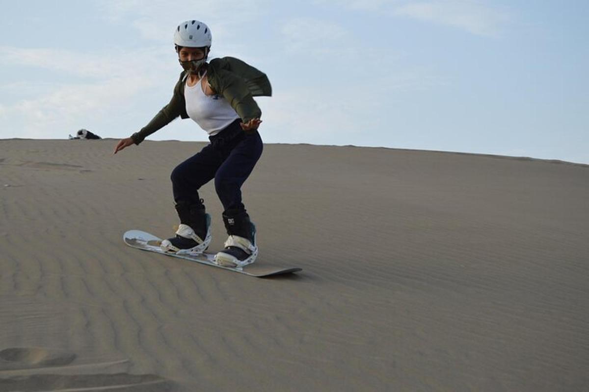 Un hombre montando una tabla de snowboard en el desierto