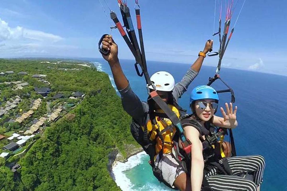 两个人乘坐降落伞飞越海洋