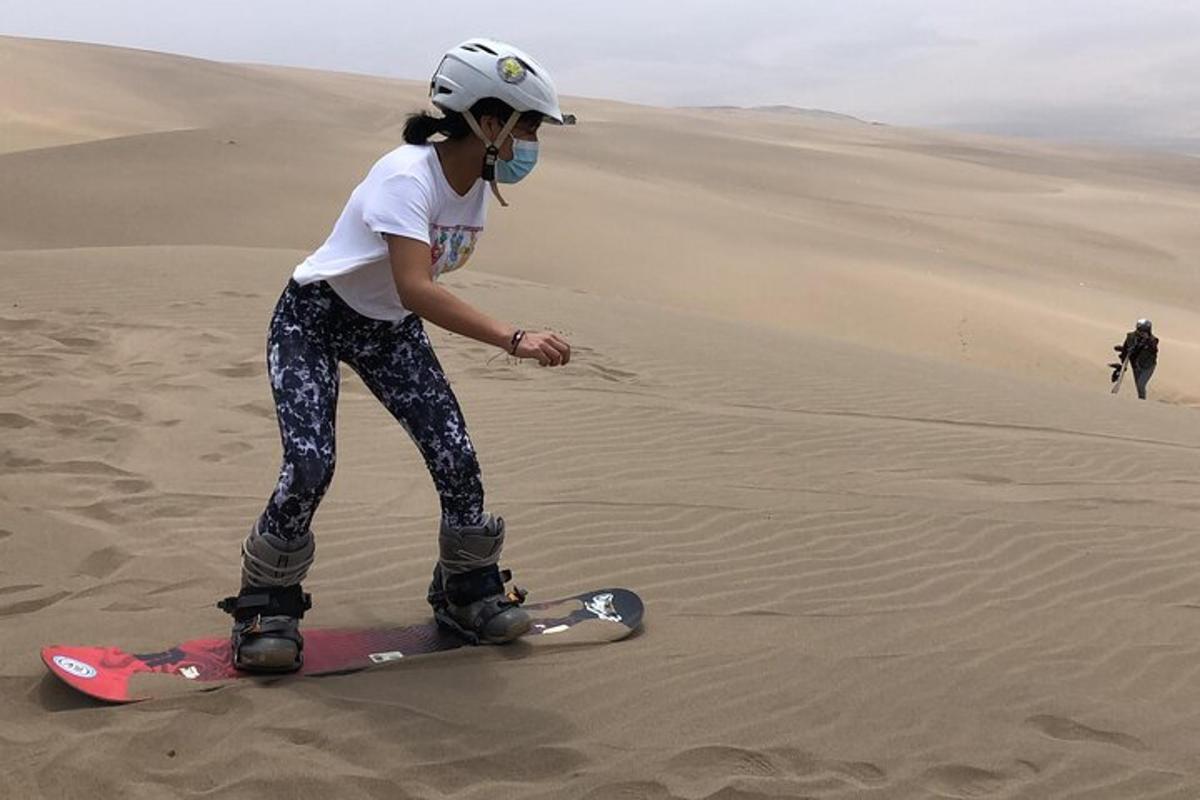 žena stojící na snowboardu v poušti