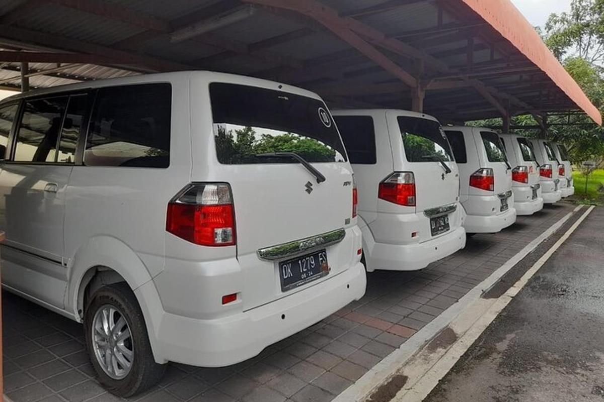 a row of white vans parked in a parking lot