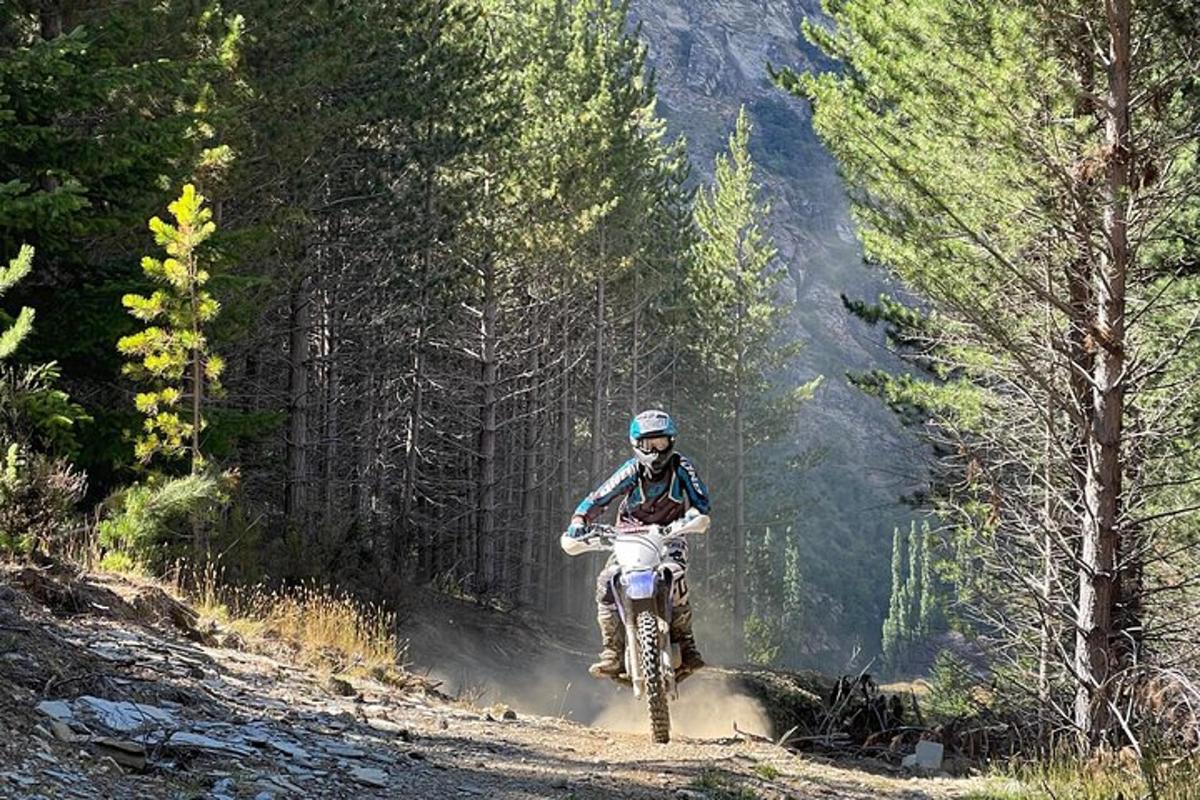 une personne conduisant une moto tout-terrain sur un chemin de terre