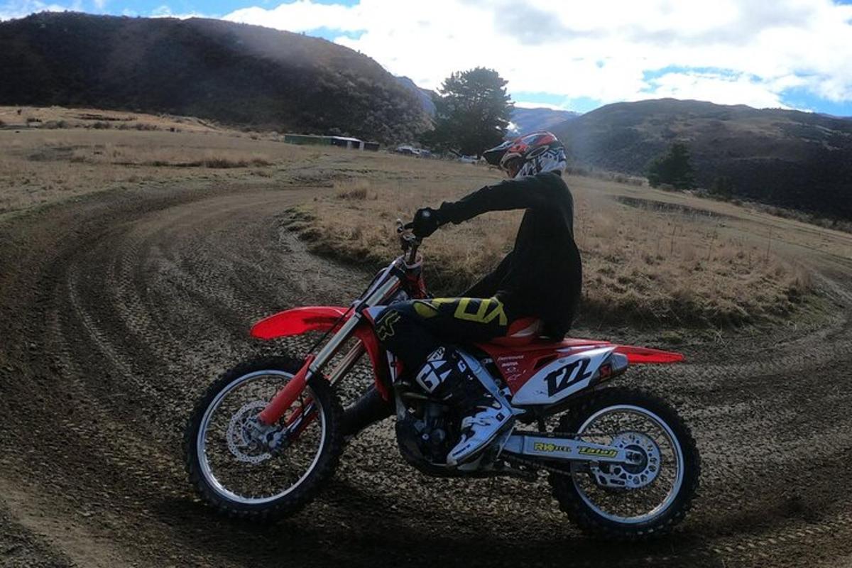 une personne conduisant une moto sur un chemin de terre
