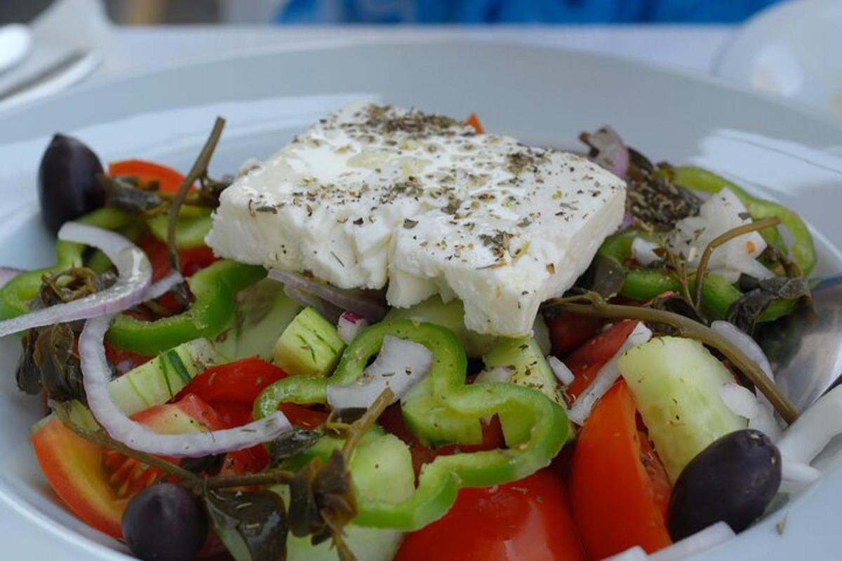 a plate of food with a salad with cheese and vegetables
