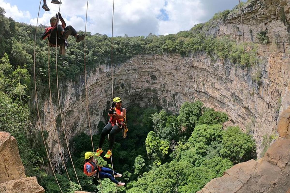 a group of people on a zip line on a cliff