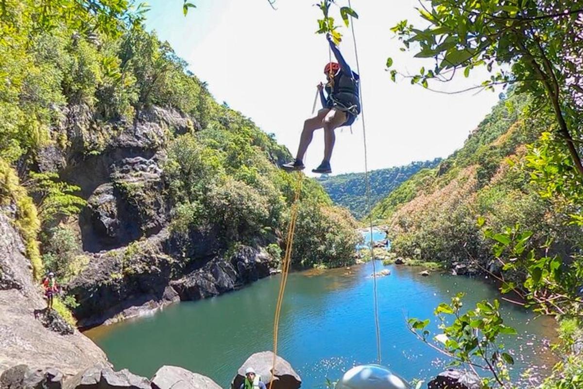 isang taong nakabitin sa isang lubid sa ibabaw ng ilog