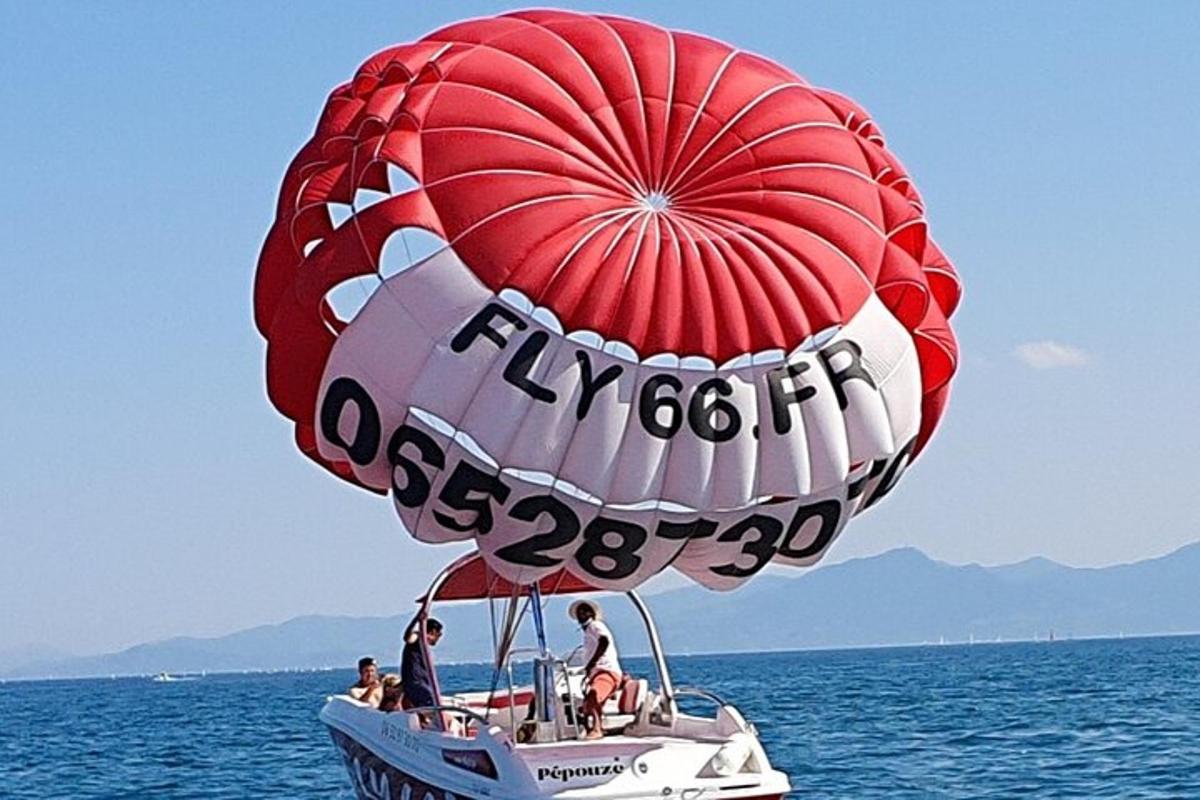 a hot air balloon flying over a boat in the water