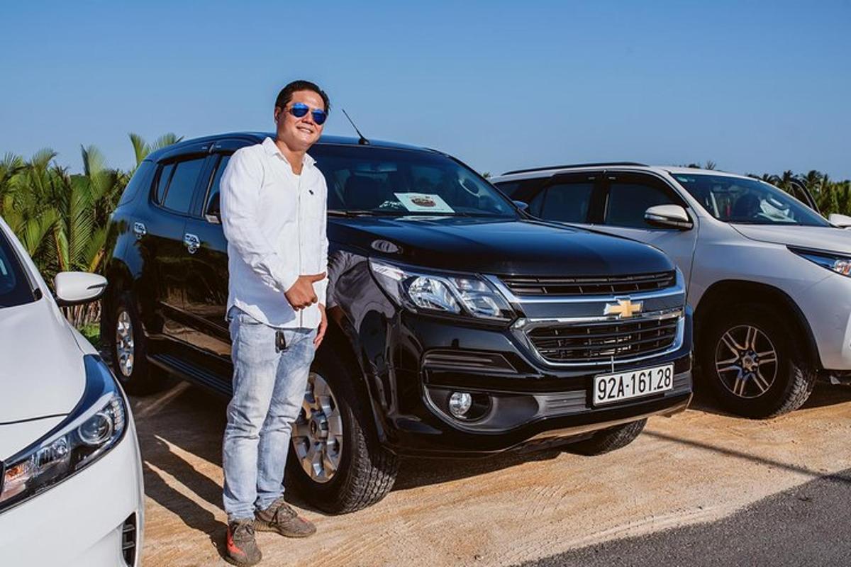 seorang lelaki berdiri di hadapan dua buah kereta
