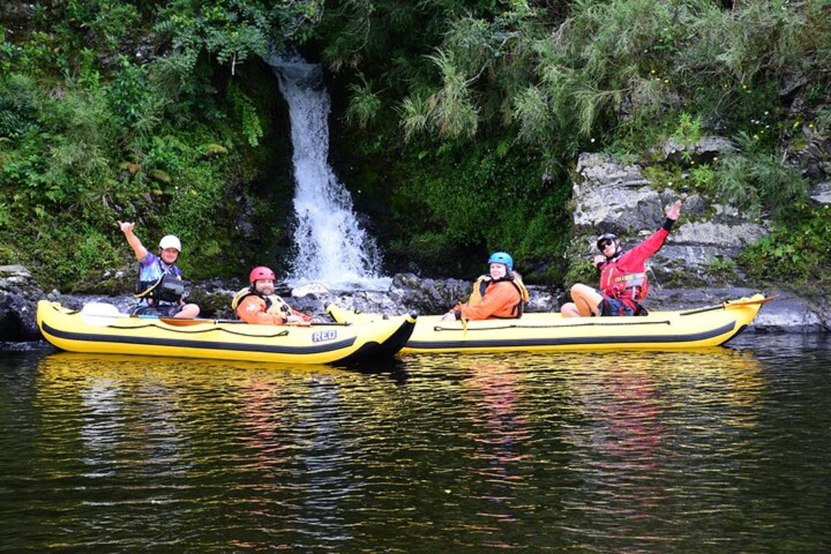 un grup de persones en caiacs en un riu amb una cascada