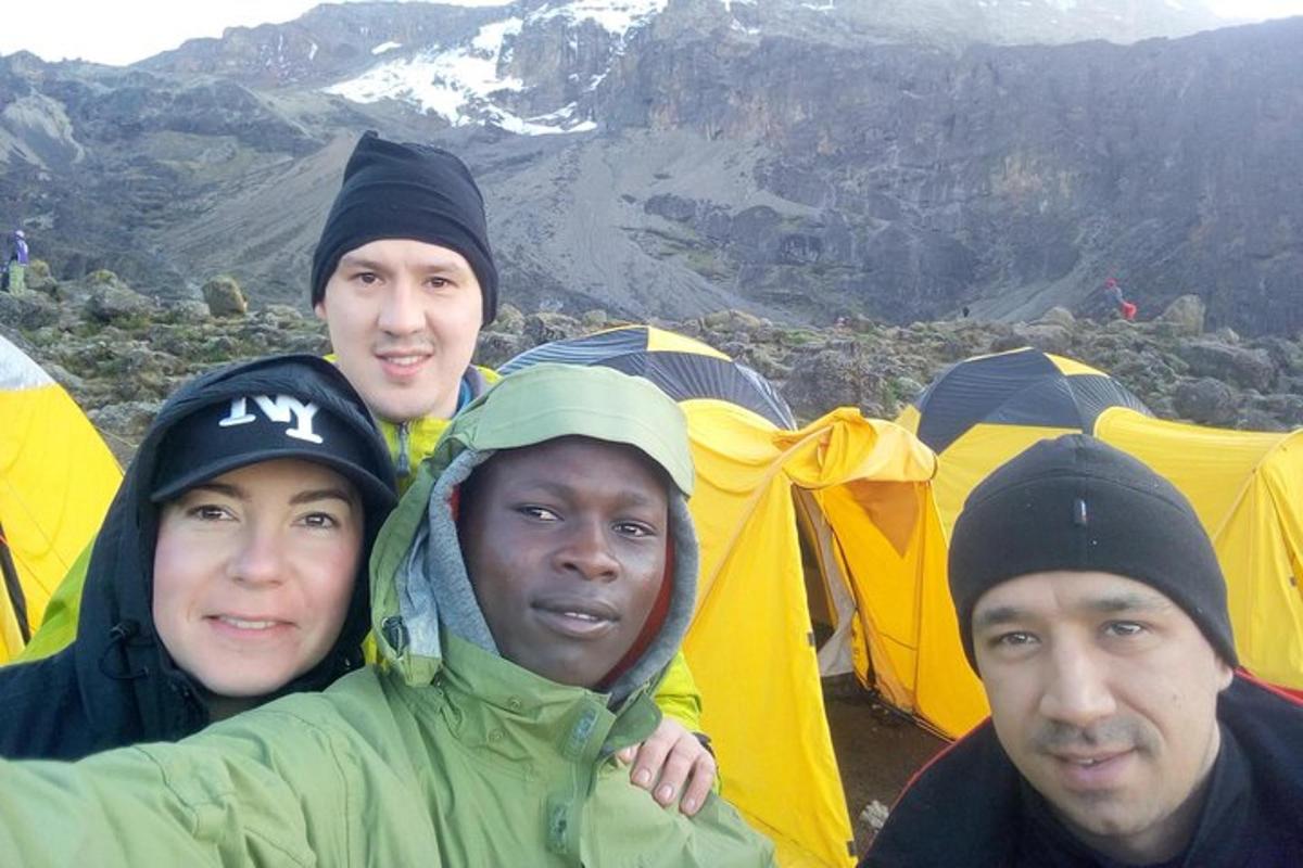 Þriggja manna hópur stendur fyrir framan tjald