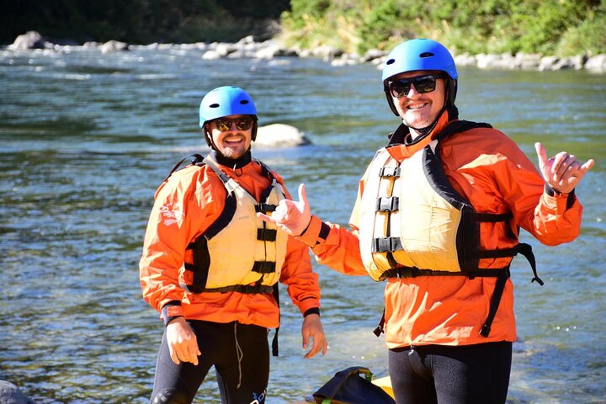 zwei Männer mit Schwimmwesten stehen in einem Fluss