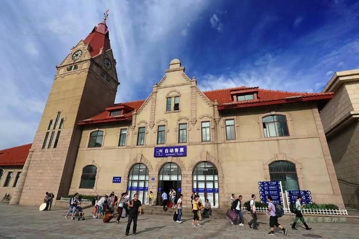 a group of people walking in front of a building with a clock tower