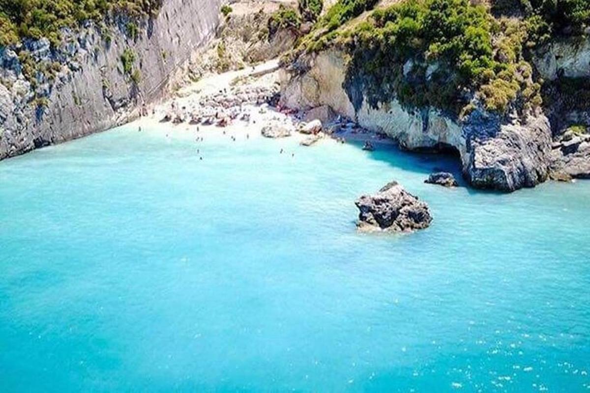une plage avec un groupe de personnes dans l'eau