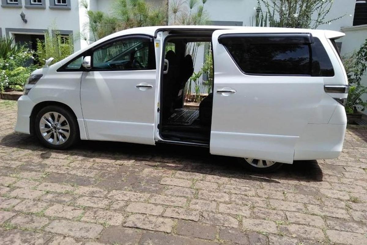 một chiếc xe tải màu trắng với cánh cửa mở trên lối đi lát gạch