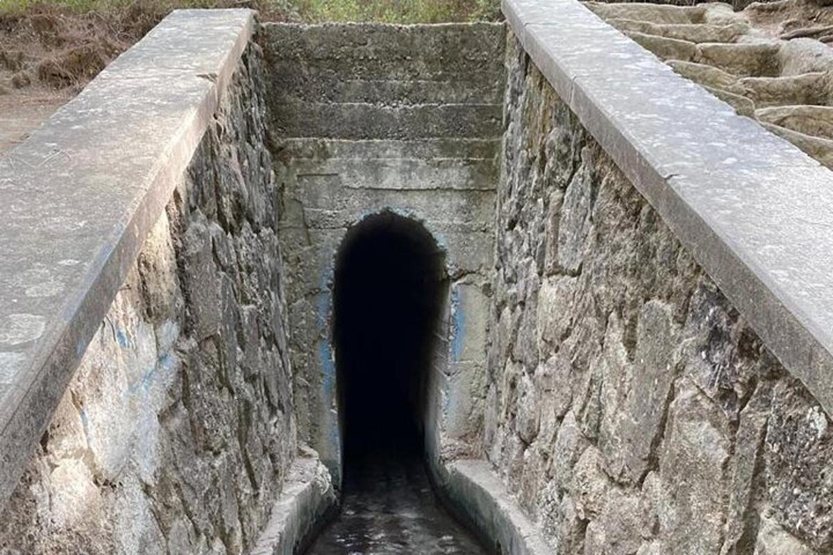 un tunnel in un muro di pietra con un tunneligunigunigunigunigunigunigun