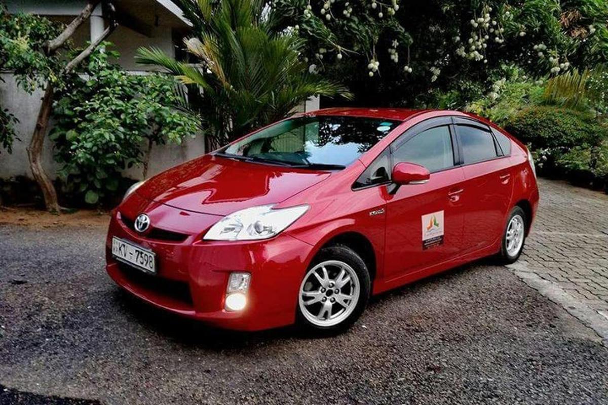 isang maliit na pulang kotse na nakaparada sa isang driveway