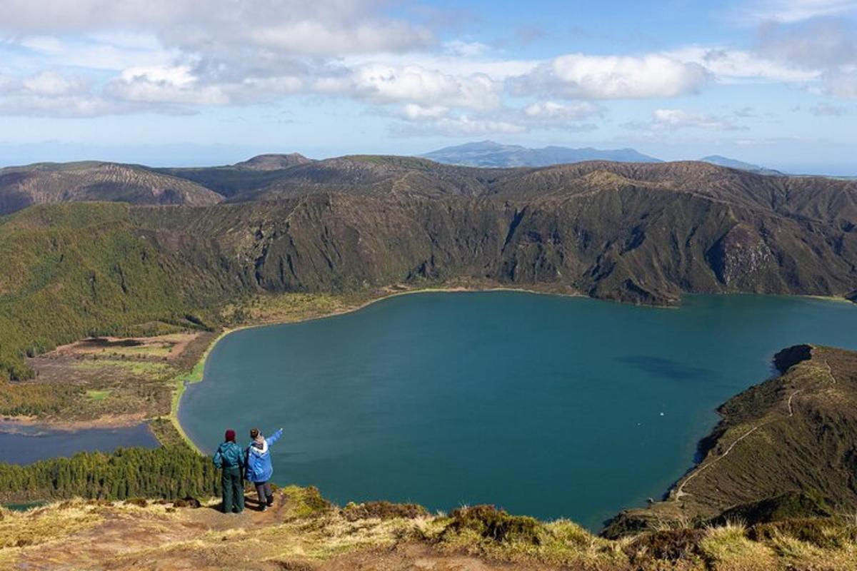 due persone in piedi sulla cima di una montagna che domina un lago