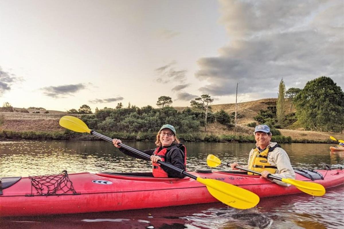 a man and woman in a red kayak on a river