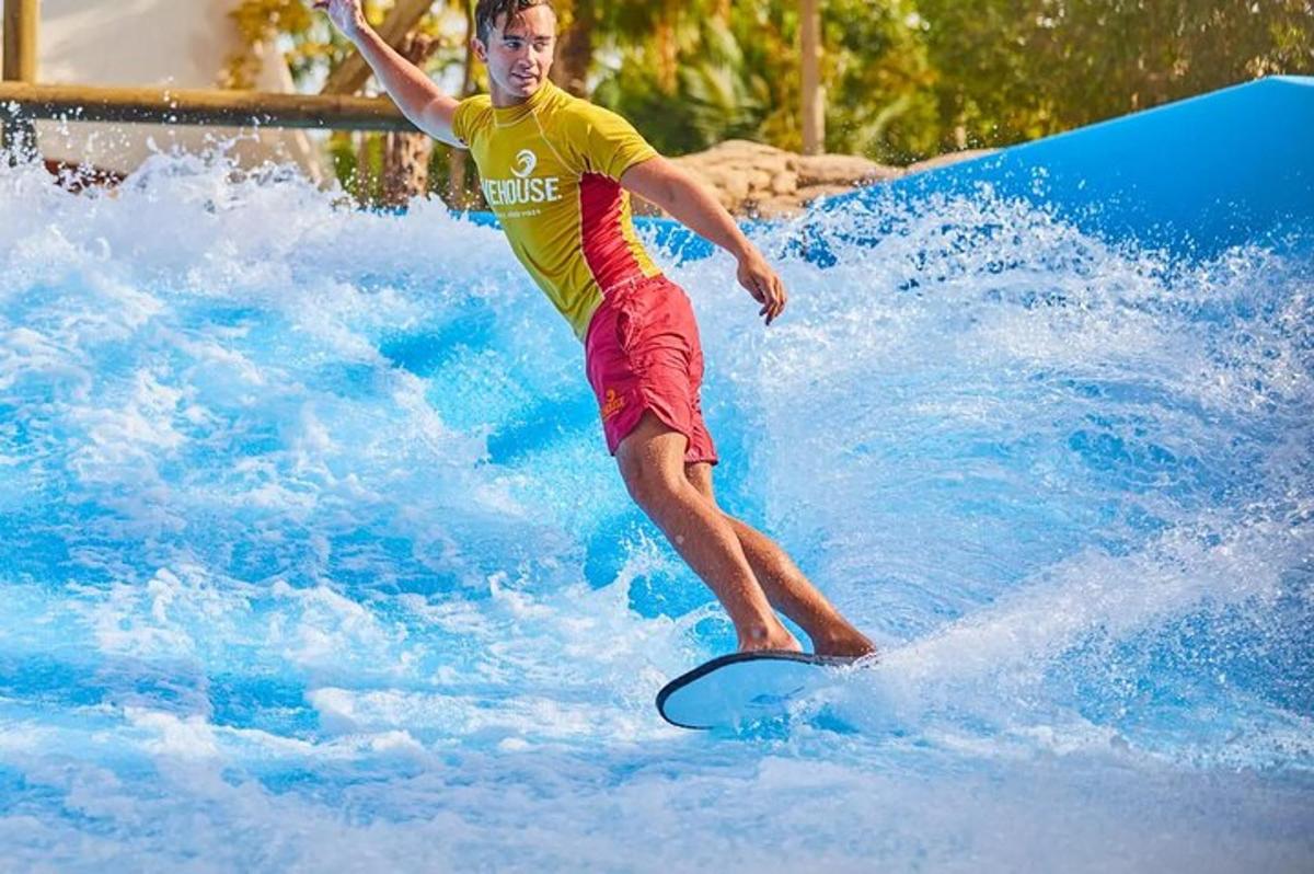a man riding a wave on a surfboard in a water park