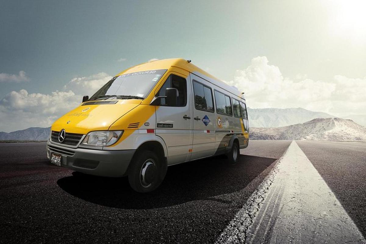 um ônibus amarelo e branco dirigindo por uma estrada