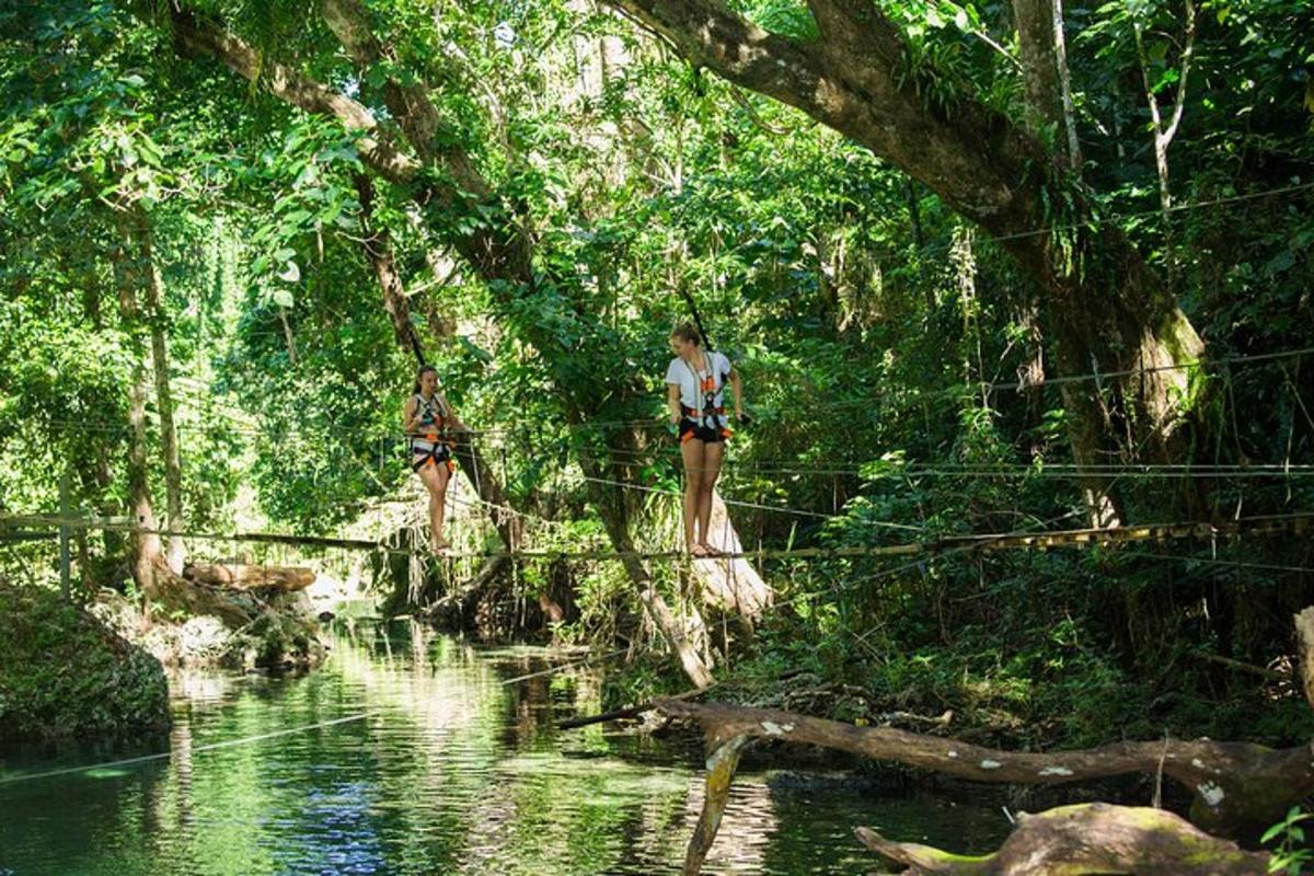 two women walking across a suspension bridge over a river