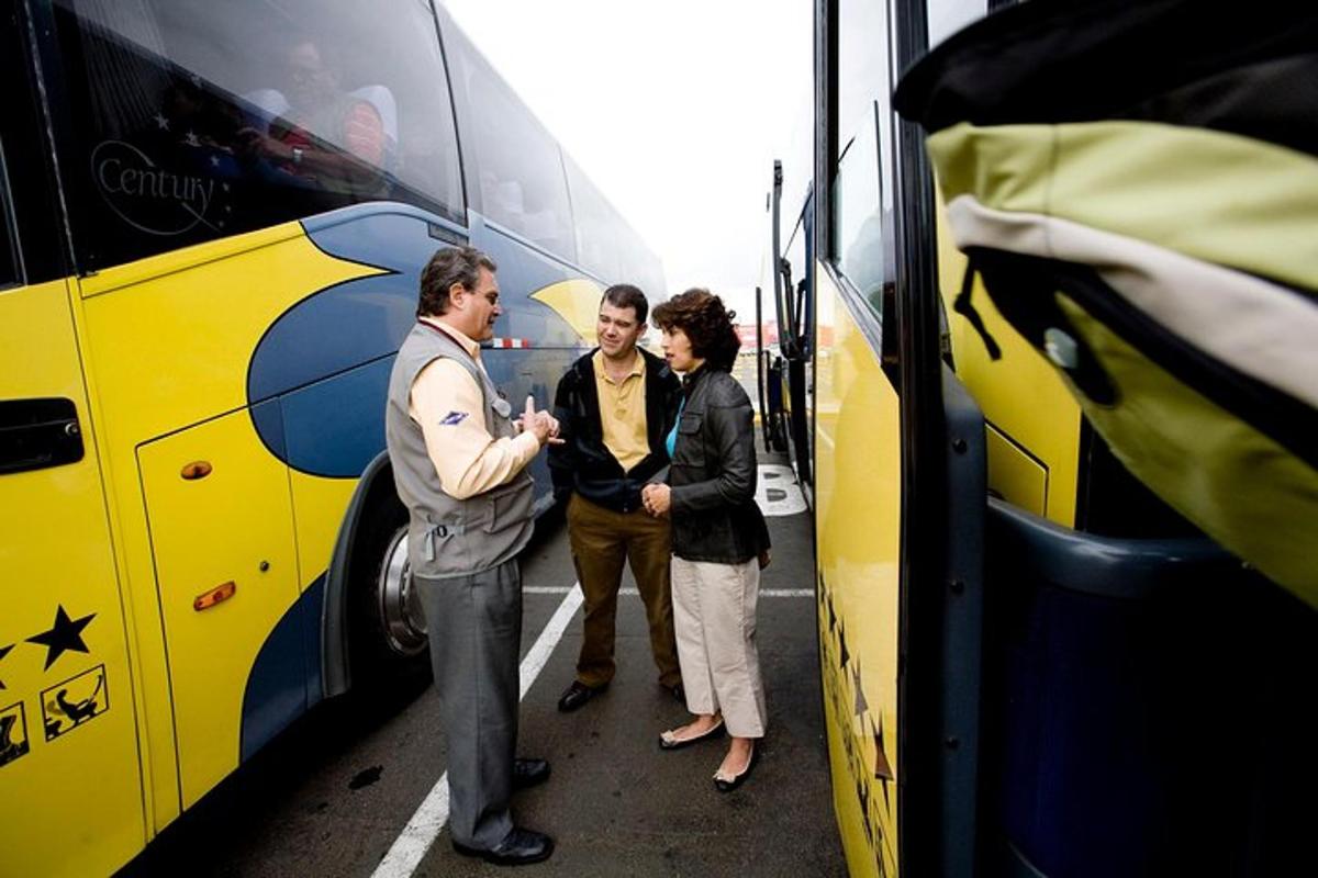 um grupo de três pessoas em pé ao lado de um ônibus