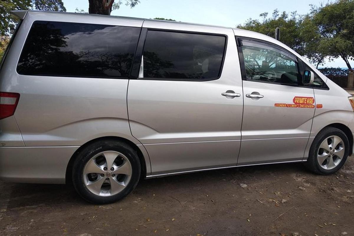 un furgone argentato parcheggiato in un parcheggio sterrato
