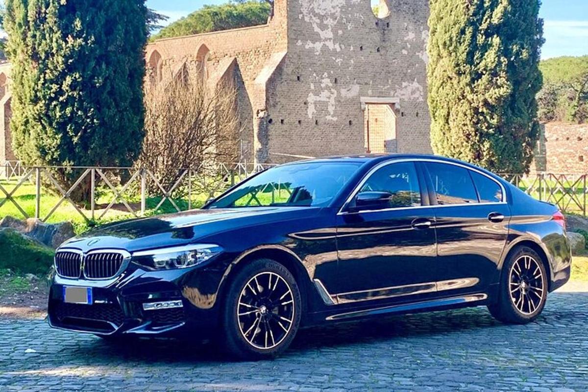 un cotxe BMW blau aparcat davant d'un castell