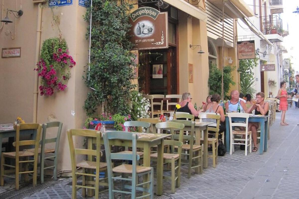 skupina lidí sedících u stolů před restaurací