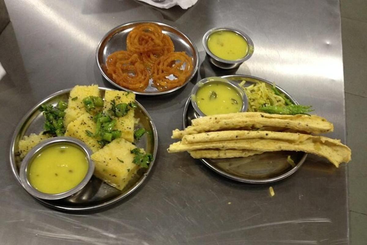 a table with four plates of food with dipping sauce
