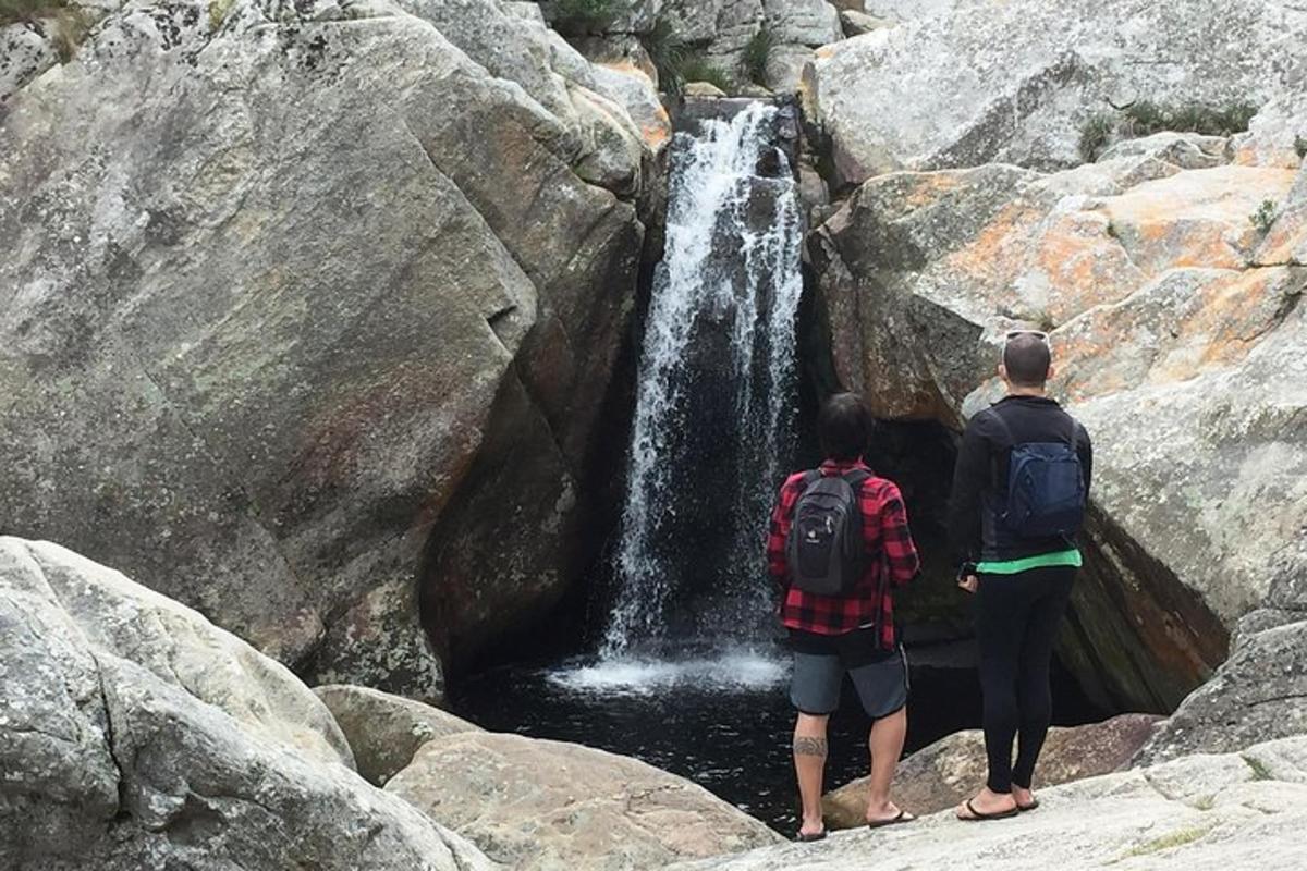 two people standing in front of a waterfall