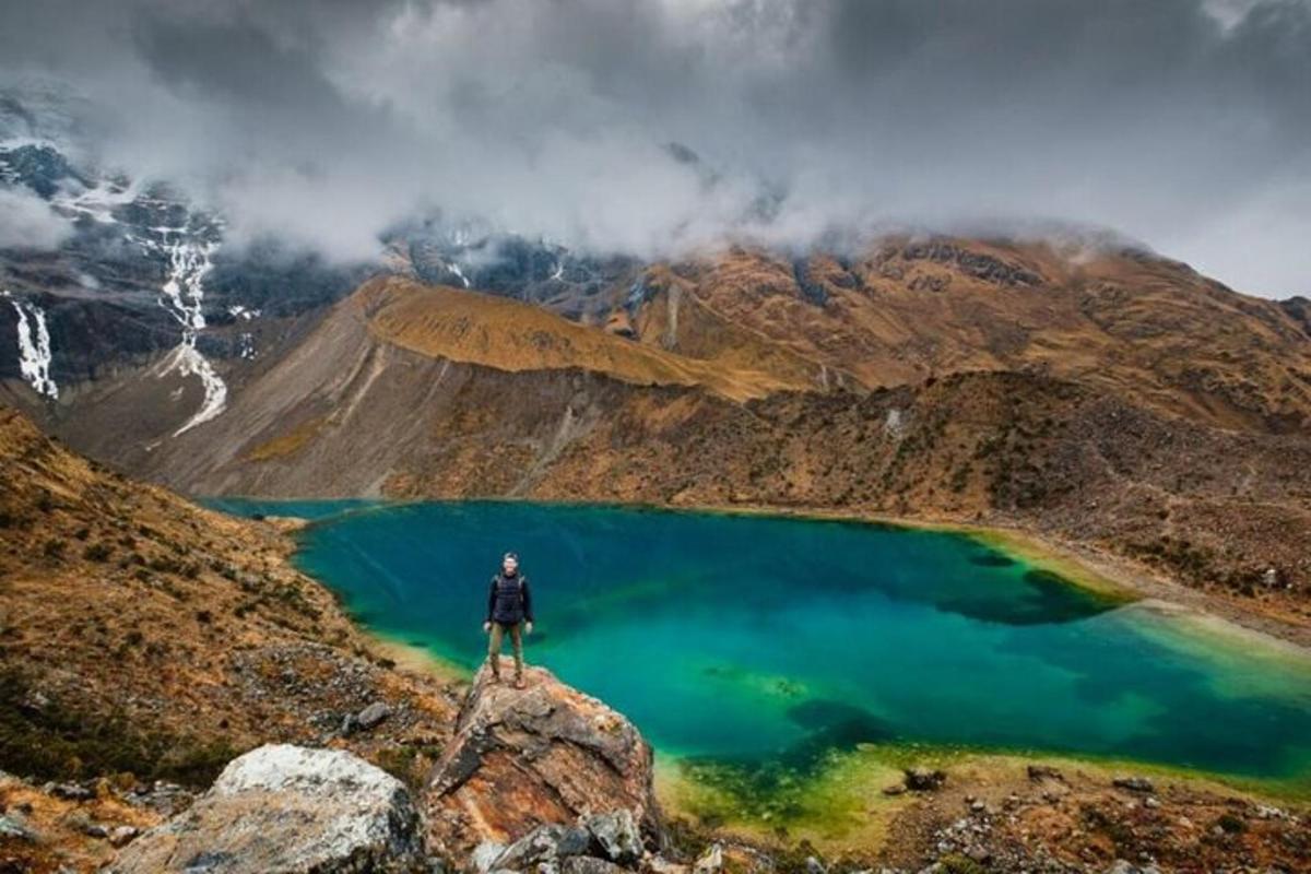 Ein Mann steht auf einem Felsen vor einem See