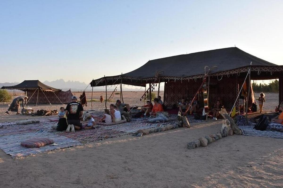 skupina ljudi, ki sedijo pod šotorom na plaži