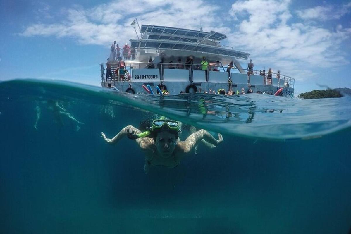 a person swimming in the water in front of a ship