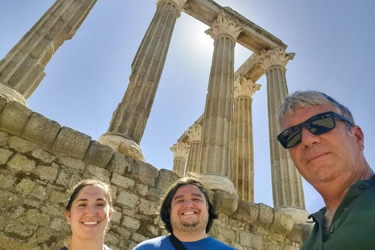 um grupo de três pessoas em pé em frente a um templo