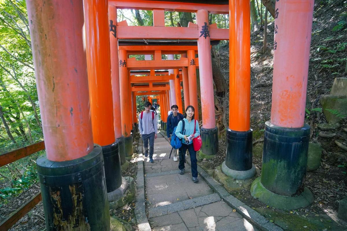 a group of people walking through an orange shrine