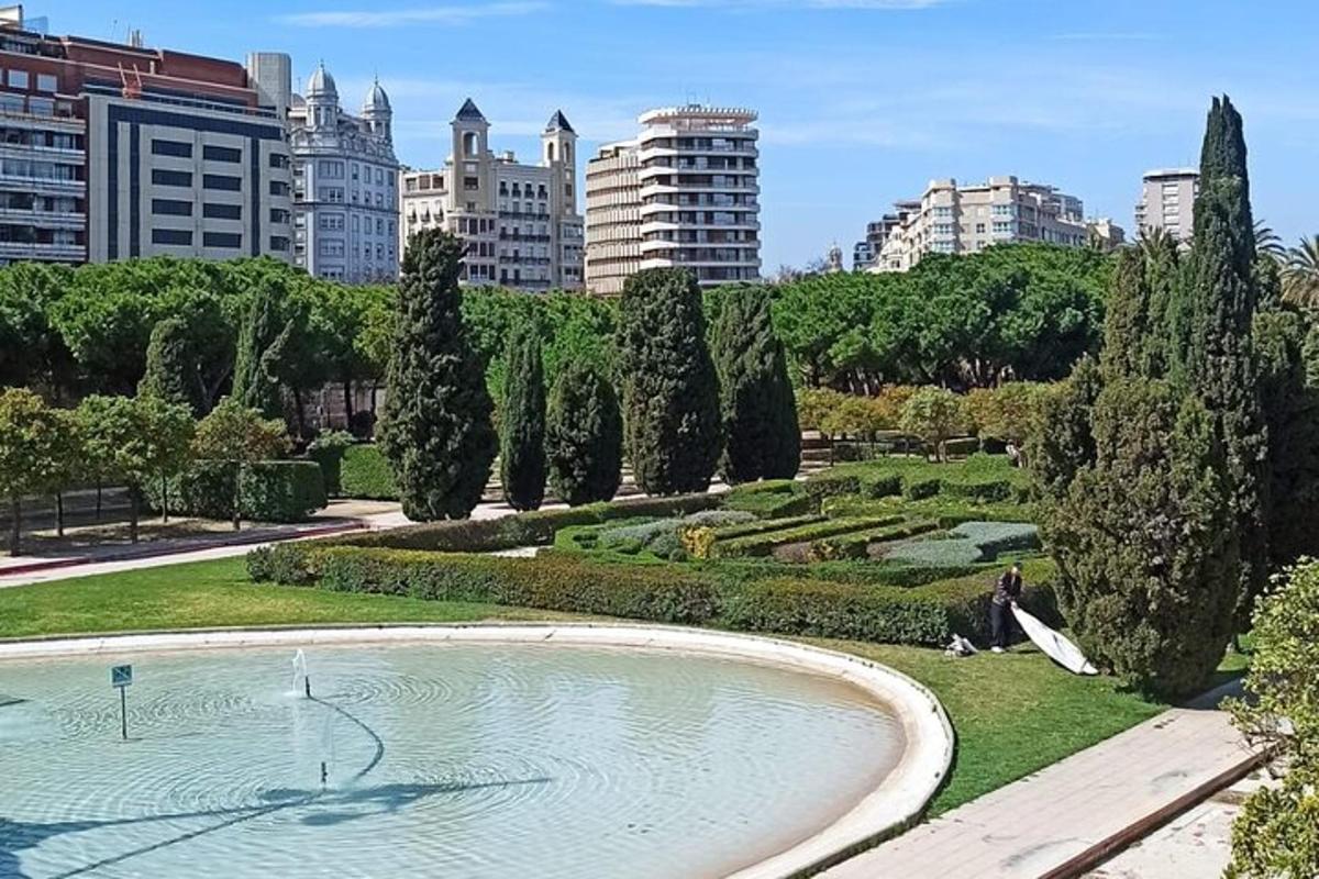 um parque com um lago, árvores e edifícios