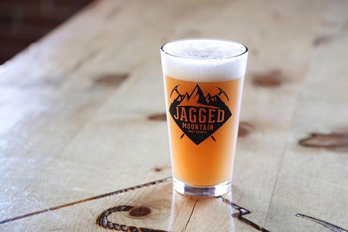 un bicchiere di birra appoggiato su un tavolo di legno