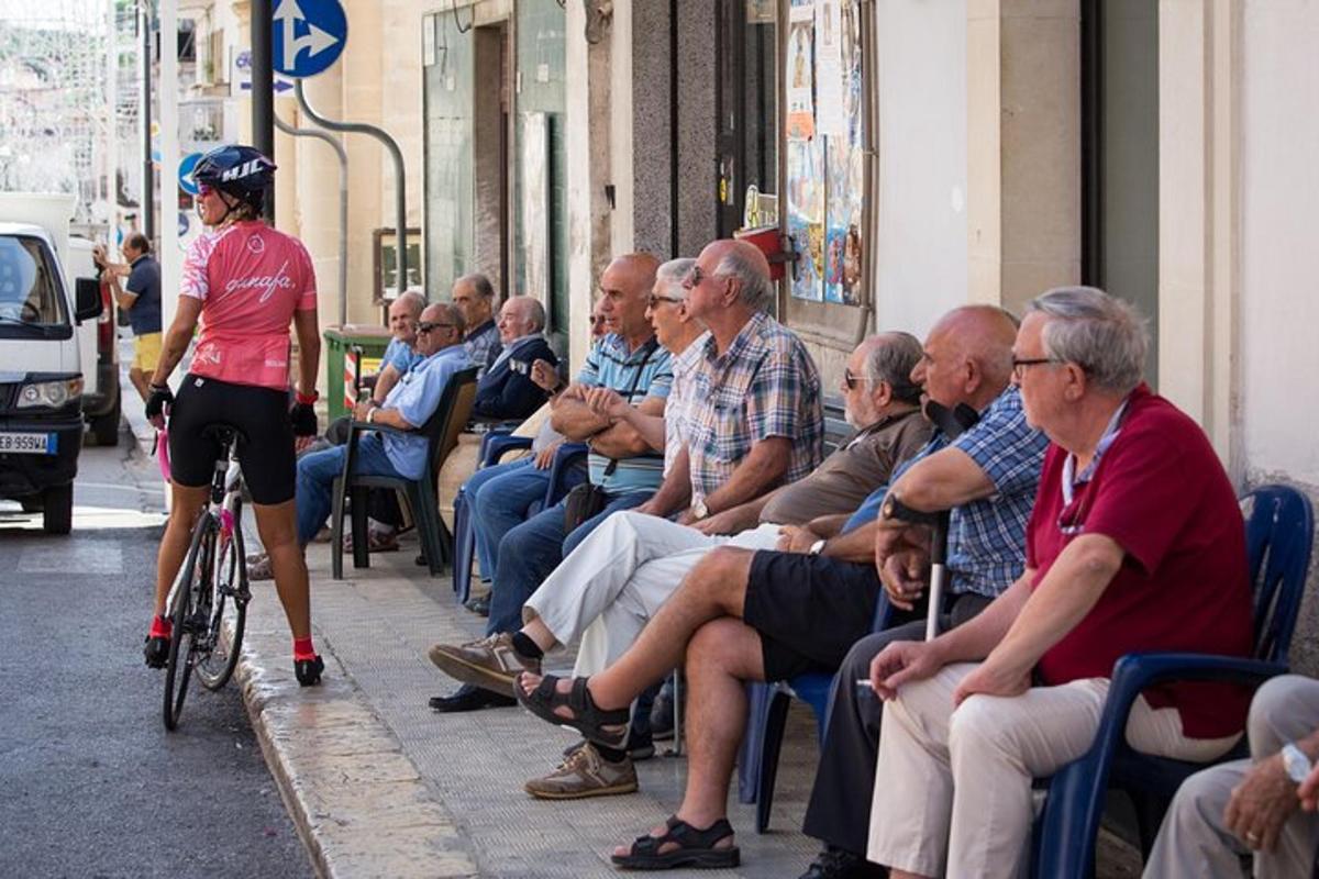 uma mulher andando de bicicleta ao lado de uma multidão de pessoas