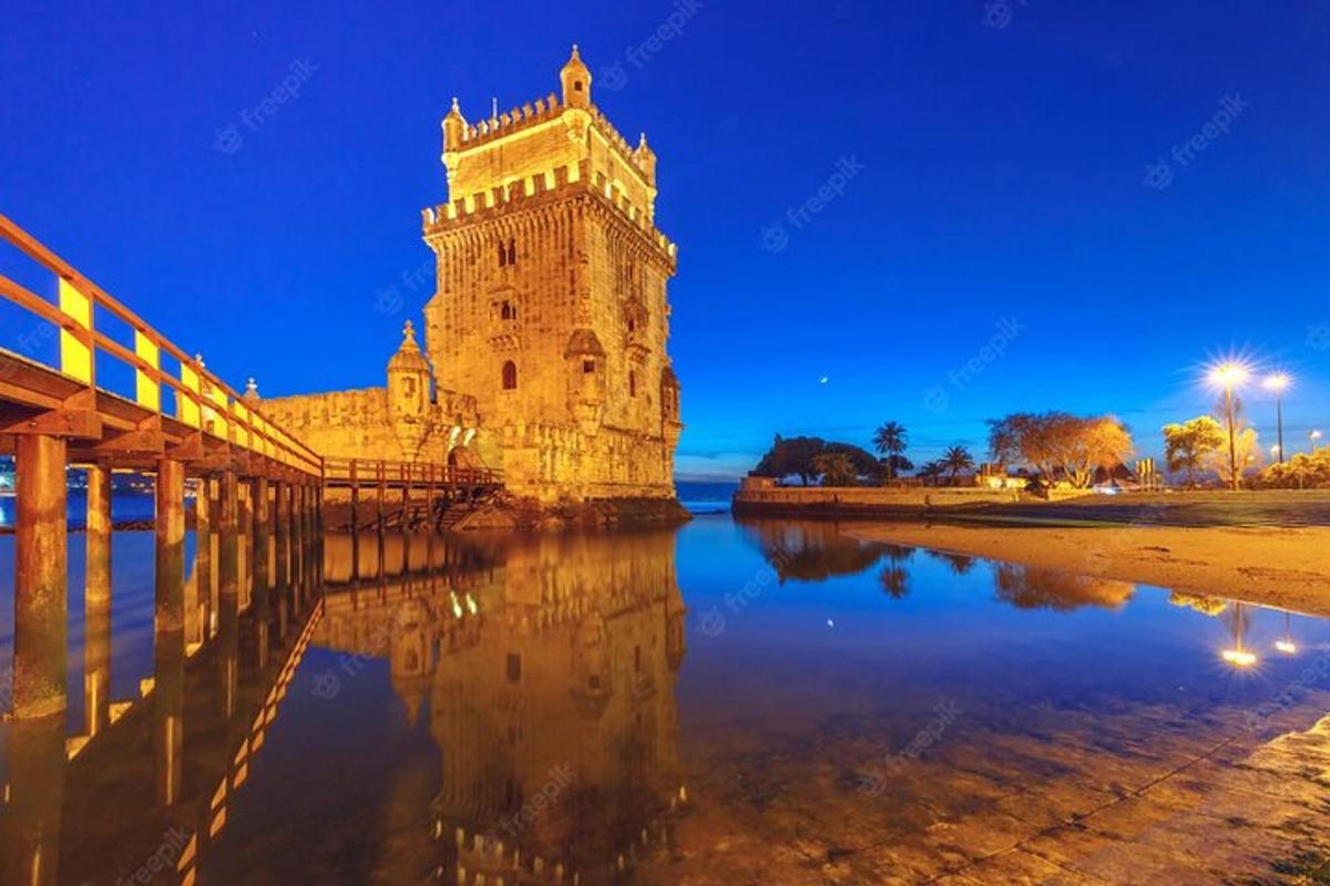 a tower on the water next to a bridge