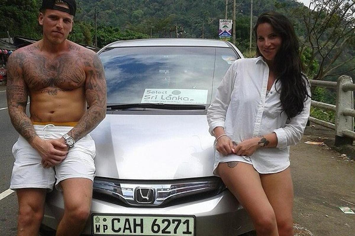 un uomo e una donna seduti sul cofano di un'auto