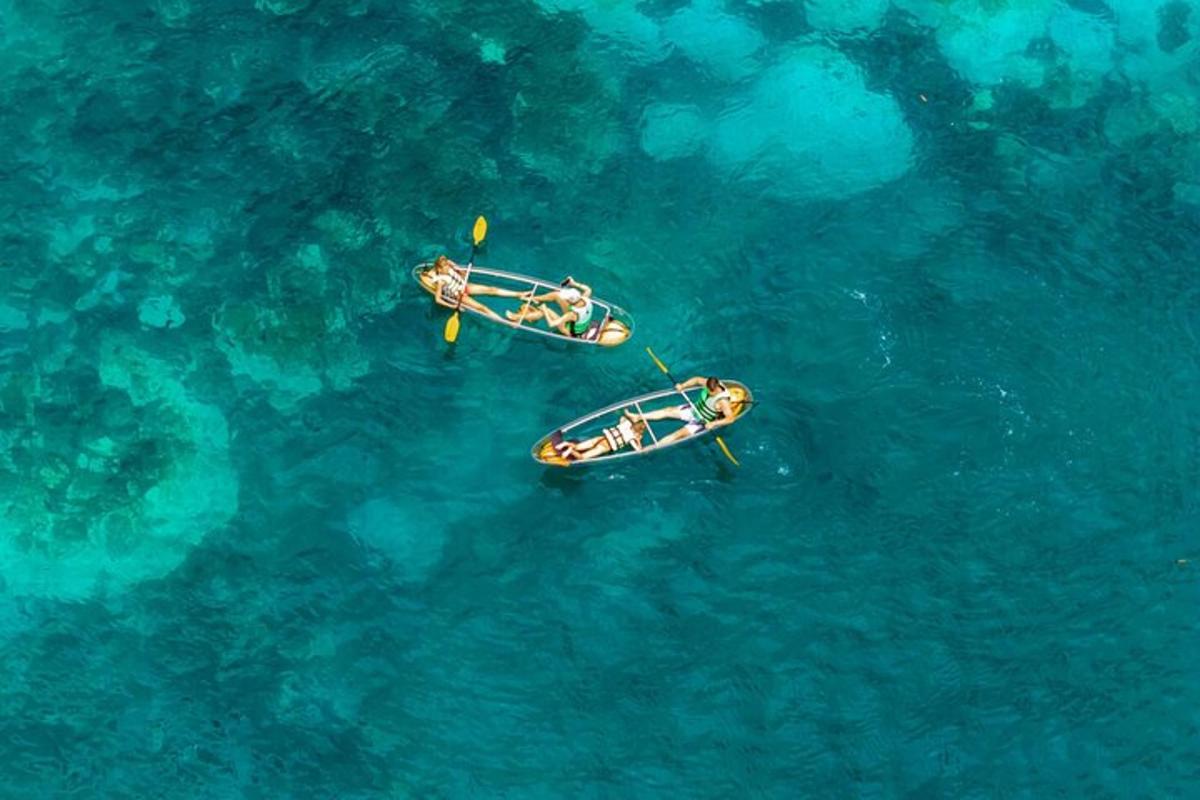 Tres personas en kayaks en el agua azul