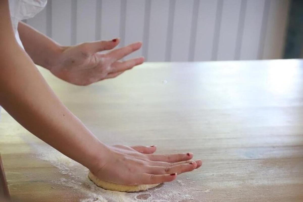 una donna sta impastando l'impasto sul pavimento